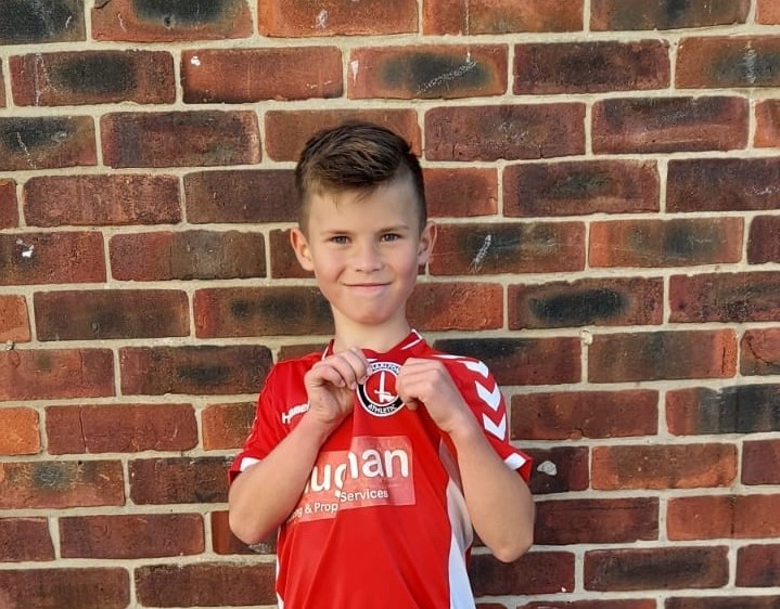 Roman holding up the Charlton Athletic badge from his shirt