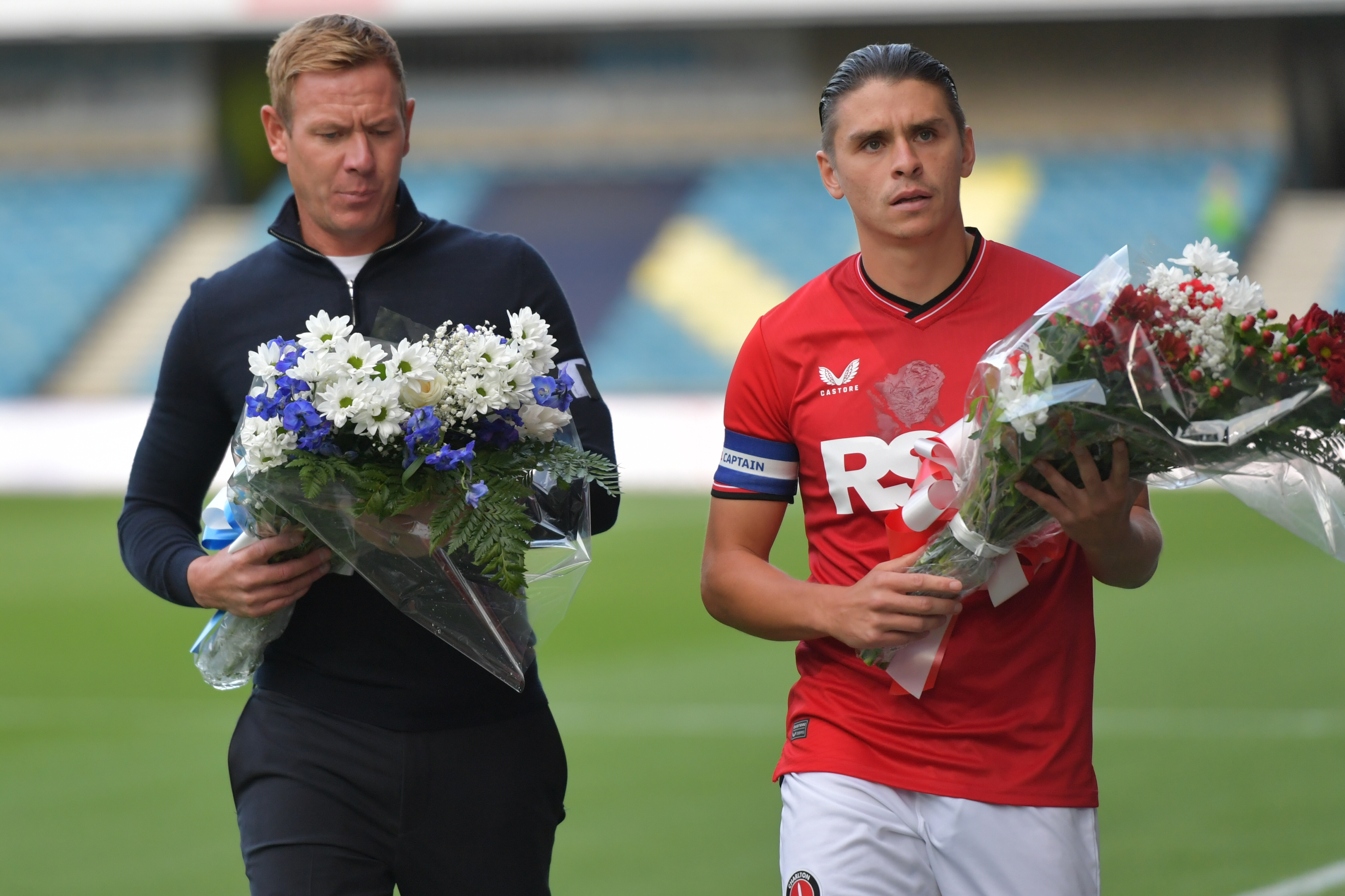 Dean Holden and George Dobson carrying flowers to pay respect to John Berlyson