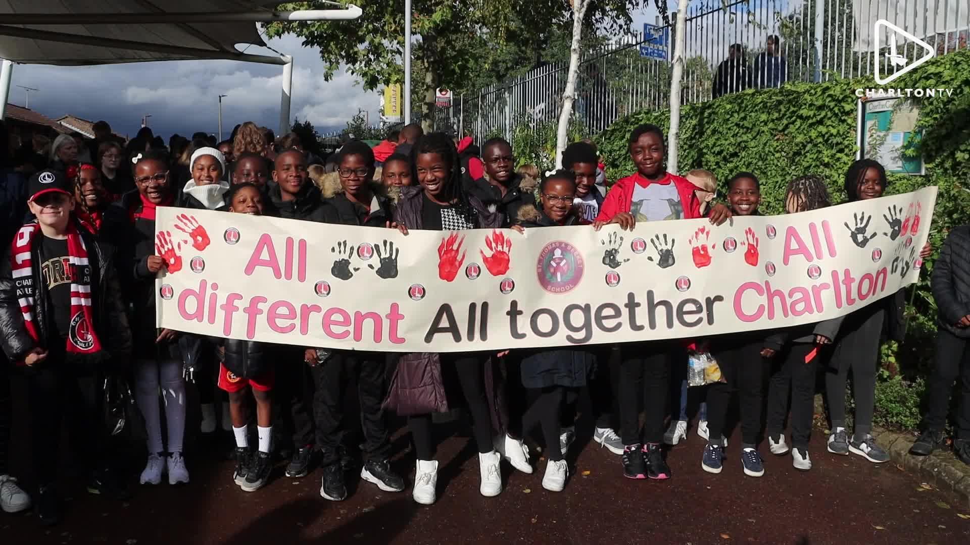Young supporters holding a banner saying "All different, all together, all Charlton"