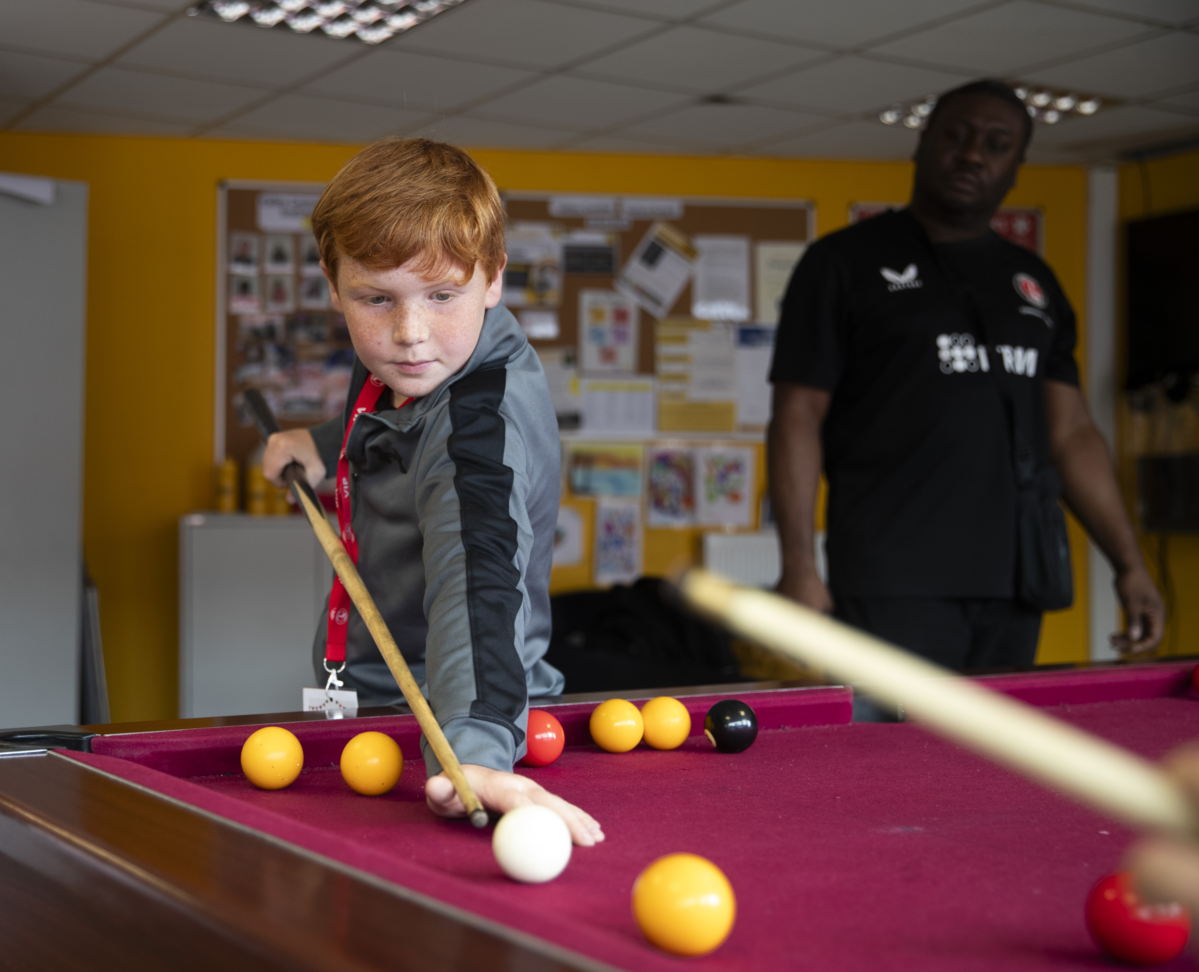 Youngster playing pool in the Family Activity Zone