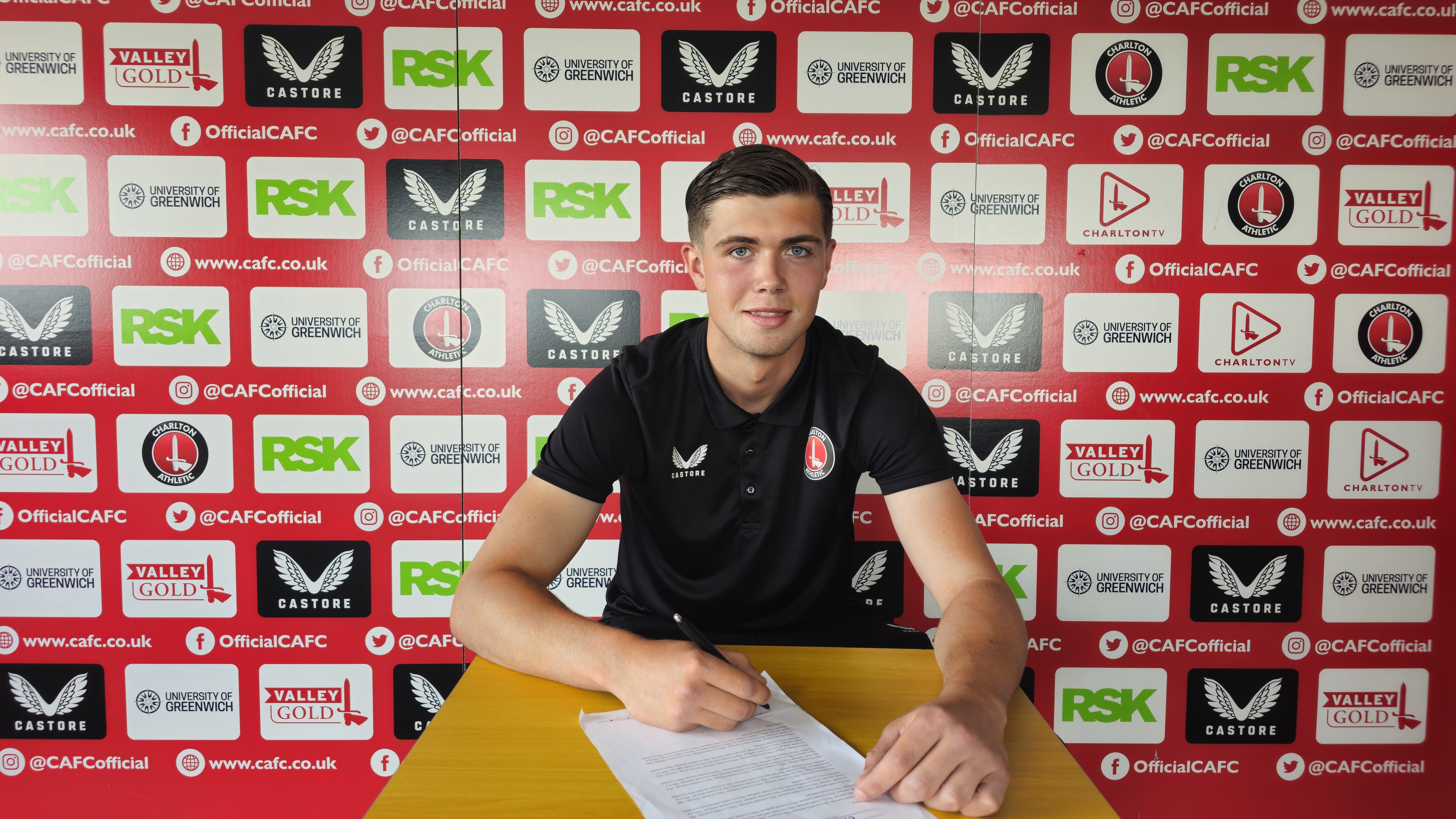 Lennon MacLorg signing a contract with Charlton Athletic.