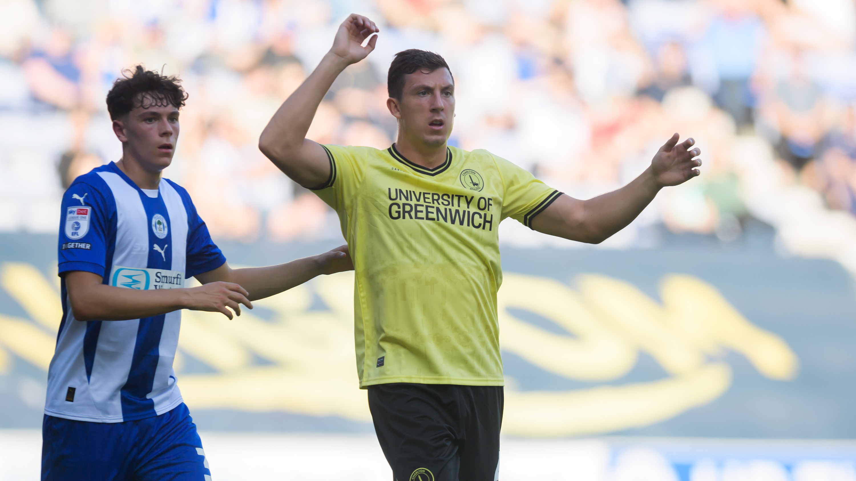 Alex Mitchell of Charlton Athletic (right) tries to free himself from Luke Chambers of Wigan Athletic during the Sky Bet League 1 match at the Brick Community Stadium, Wigan