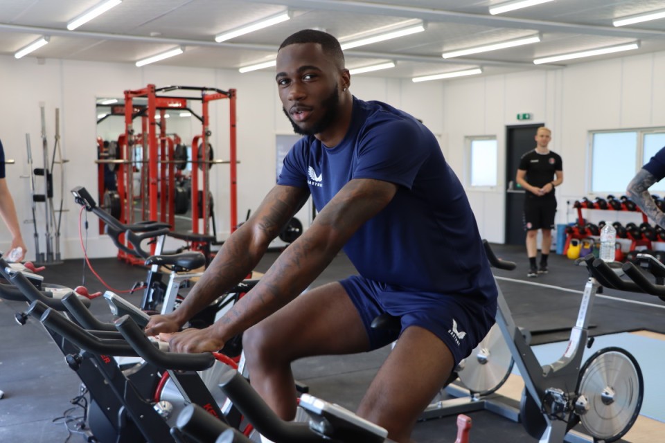 Corey Blackett-Taylor smiles to the camera while on an exercise bike
