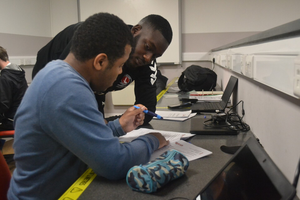 CACT staff helping a young person with their work