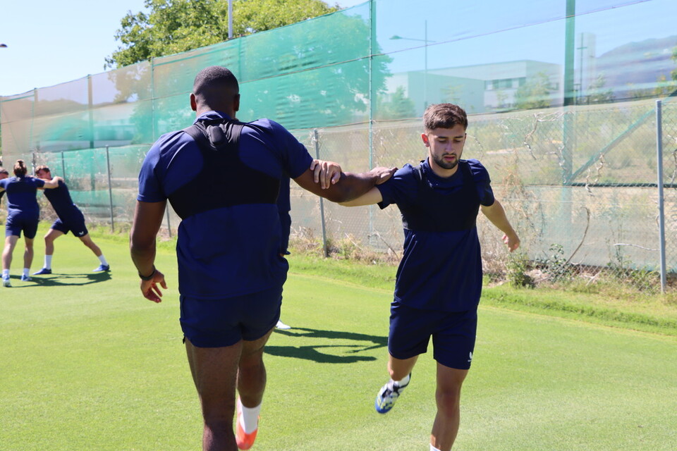 Chuks Aneke and Aaron Henry use each other to balance while performing a stretch