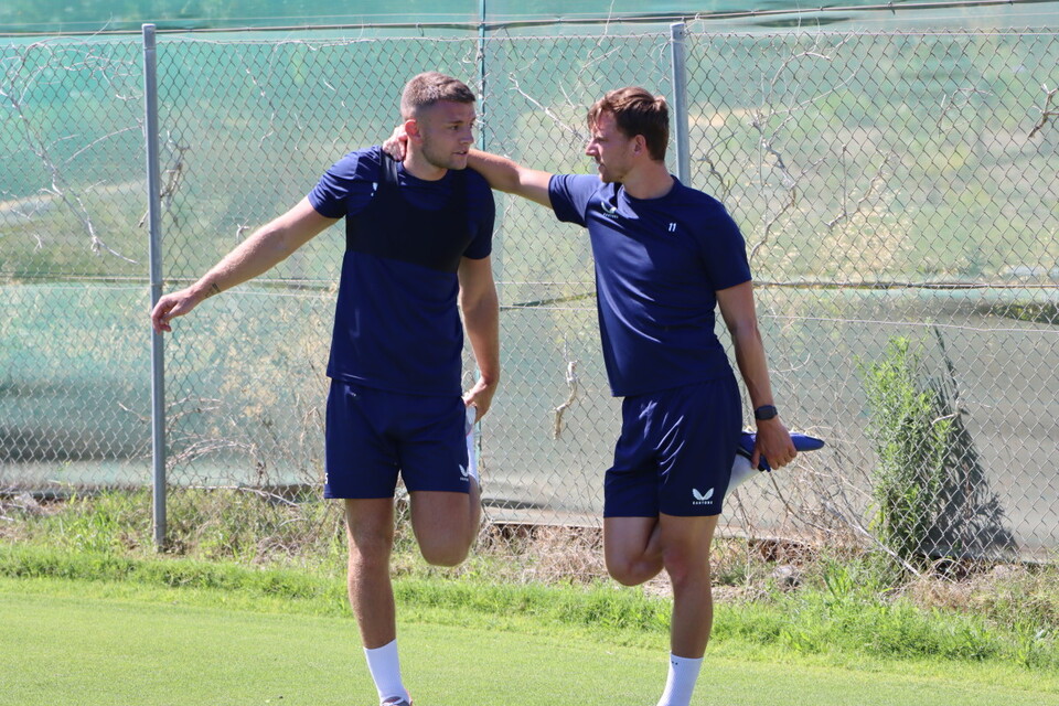 Sam Lavelle and Alex Gilbey use each other to balance while performing a stretch