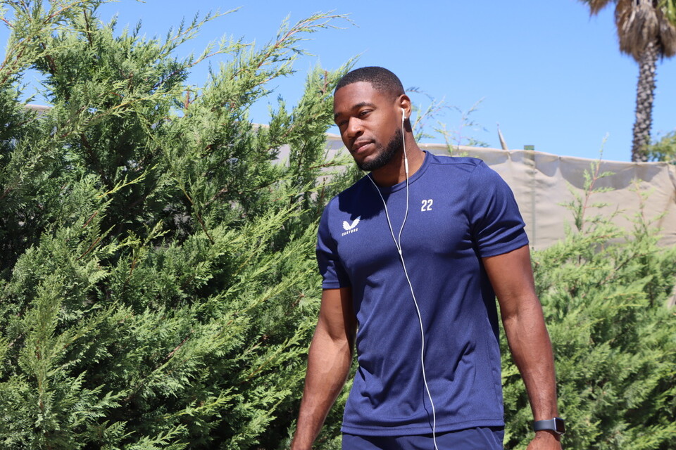 Chuks Aneke walks back to the team's hotel with his earphones in