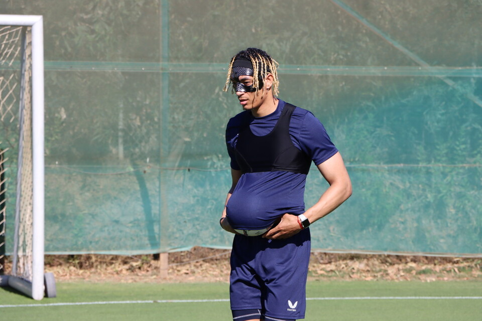 Sean Clare in pre-season training with a football under his shirt