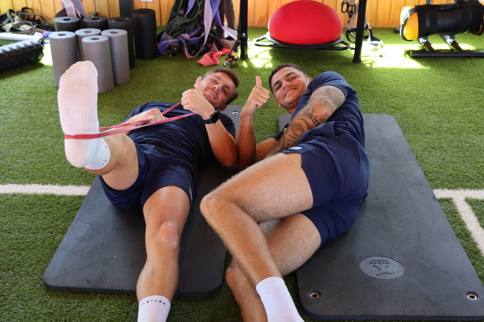 Alex Gilbey and Ryan Inniss pose for the camera in the gym