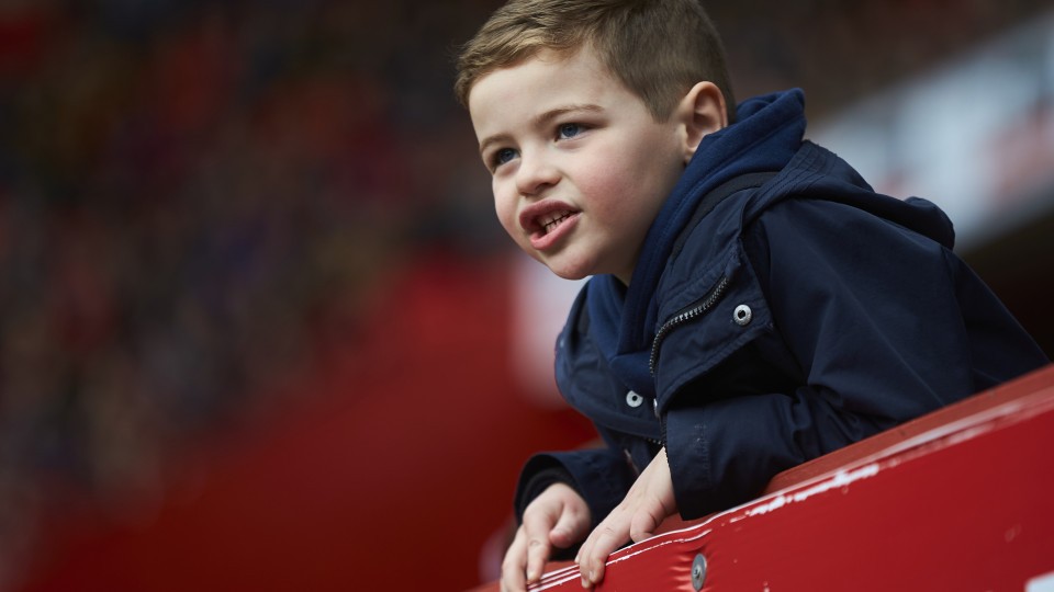 A young Charlton supporter cheers on from the stands
