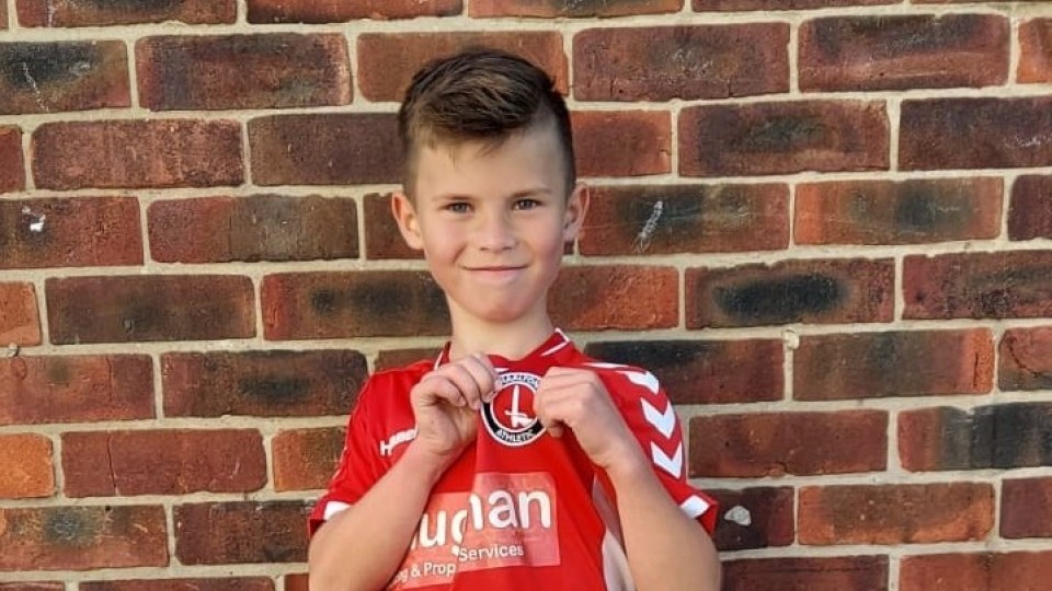 Roman holding up the Charlton Athletic badge from his shirt