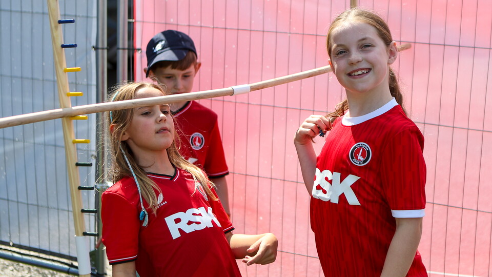 Charlton supporters try out the limbo in the Fan Zone