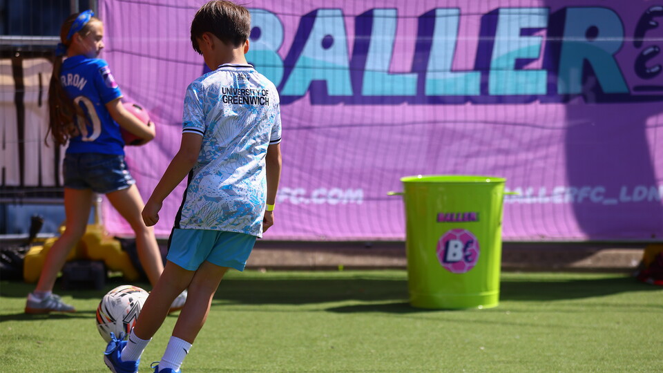 Kid kicking ball into bin