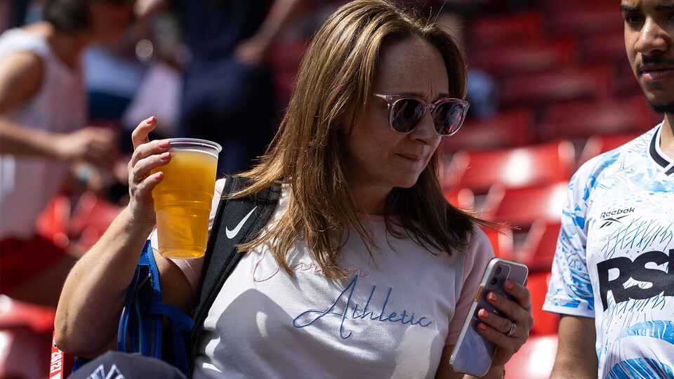 Woman with drink in the stands